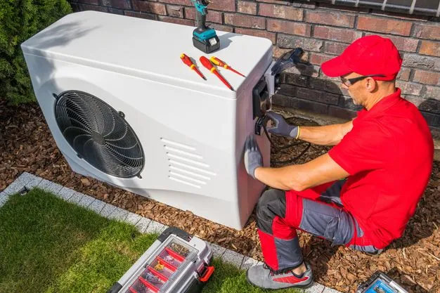 Ein Handwerker baut eine Wärmepumpe ein.