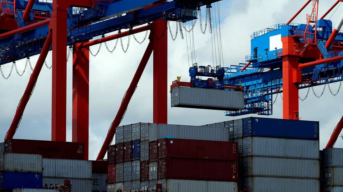 Container werden in einem Hafen auf ein Schiff verladen.