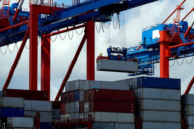 Container werden in einem Hafen auf ein Schiff verladen.
