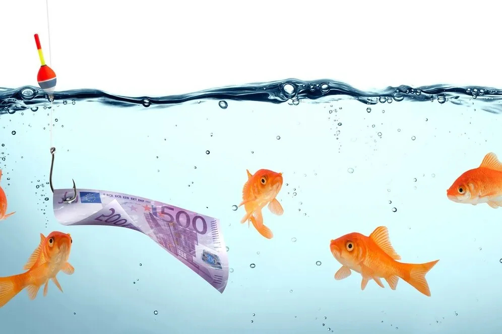 Goldfische schwimmen im Wasser, neben ihnen schwimmt ein 500 Euro Geldschein.