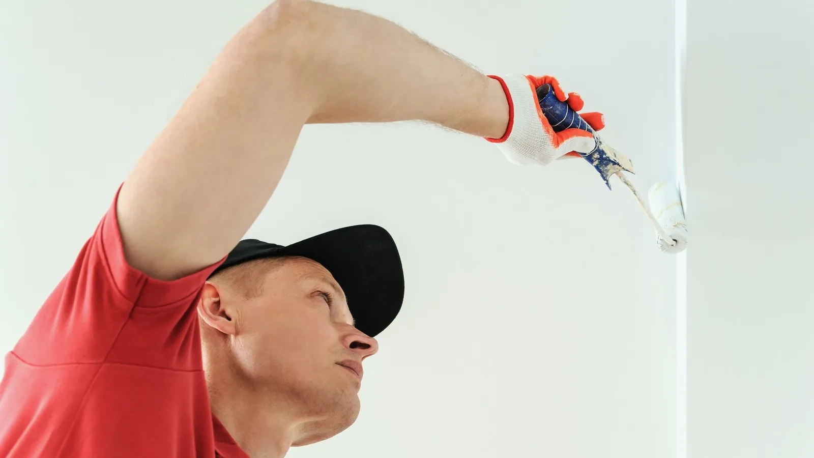 Ein Maler mit schwarzer Cap streicht die Wand.