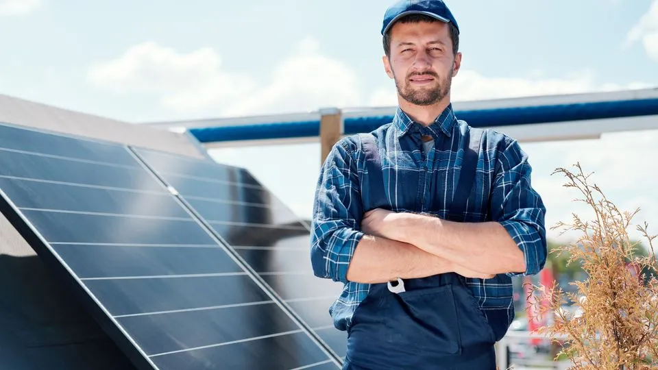 Handwerker posiert vor Photovoltaikanlage