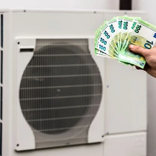 Wärmepumpe: Jemand hält eine Hand mit diversen 100-Euro-Scheinen vor das Gerät.