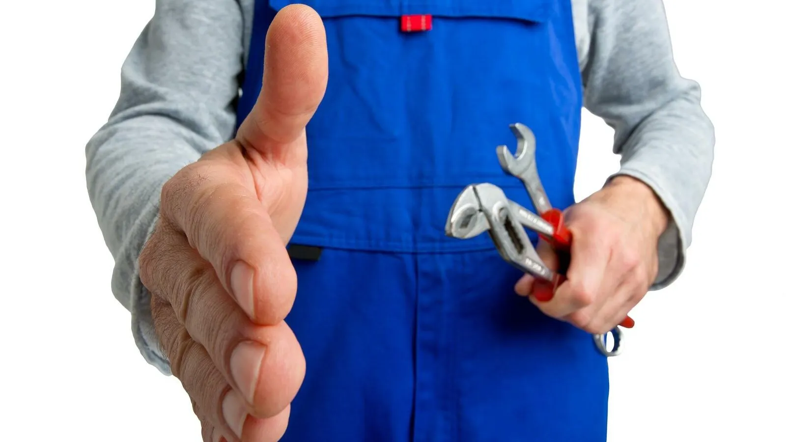 Ein Ausschnitt eines Handwerkers in einer blauen Latzhose, der zur Begrüßung seine Hand ausstreckt. In der anderen Hand hält er Werkzeuge.