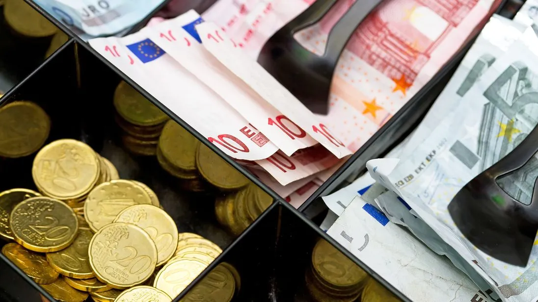 Kasse mit Euro-scheinen und Münzen