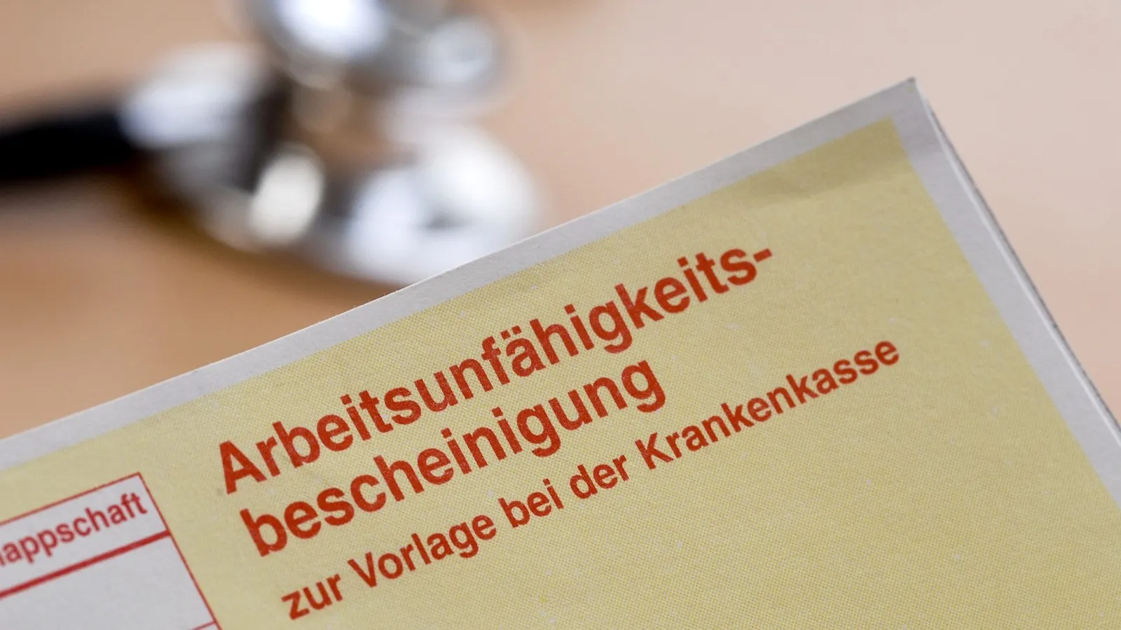 Eine gelbe AU-Bescheinigung mir roter Schrift.