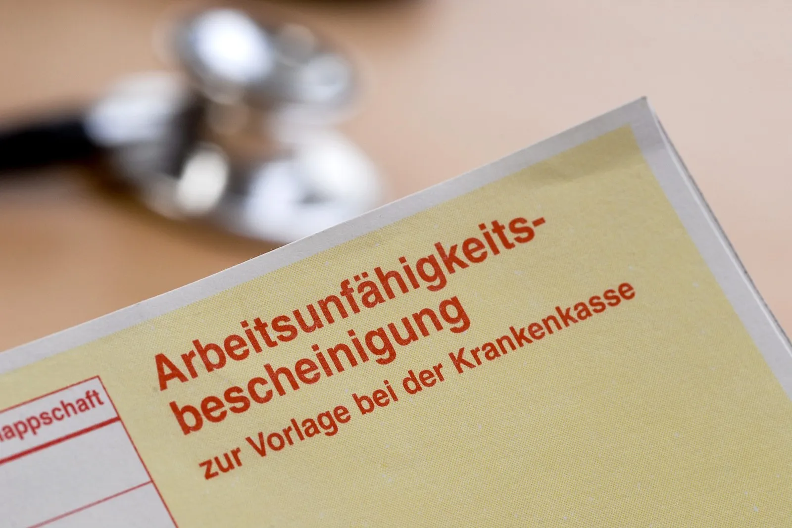 Eine gelbe AU-Bescheinigung mir roter Schrift.