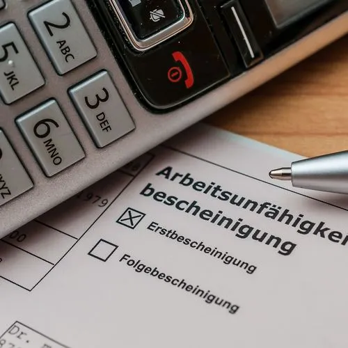 Ein Telefonhörer liegt neben neben einer Arbeitsunfähigkeitsbescheinigung