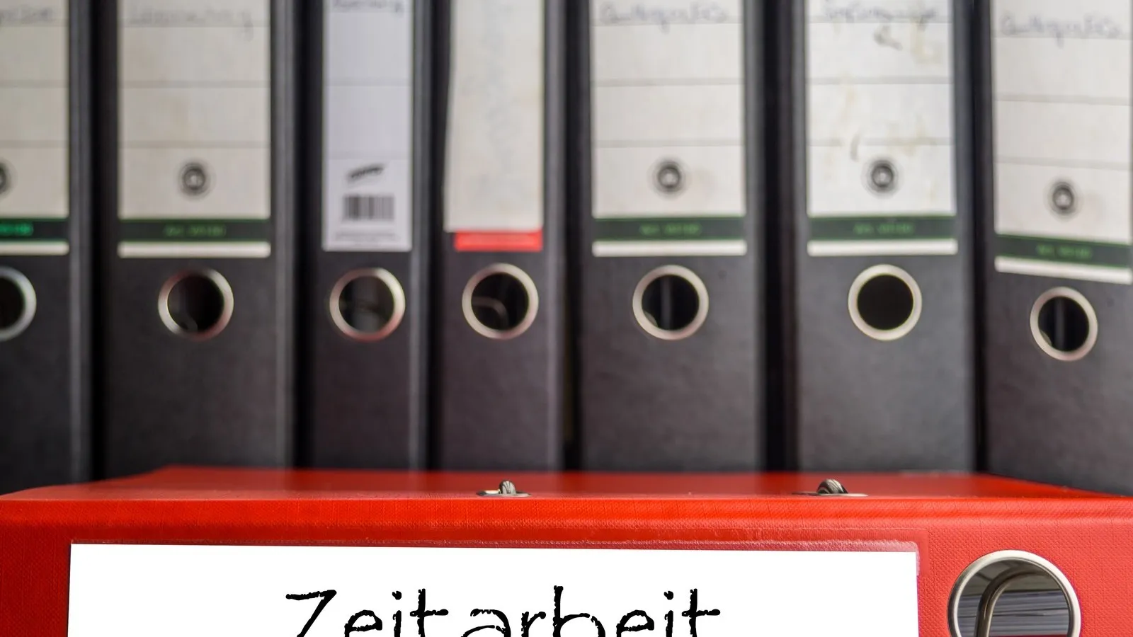 Verschiedene Ordner im Büro. Einer davon trägt die Aufschrift Zeitarbeit.