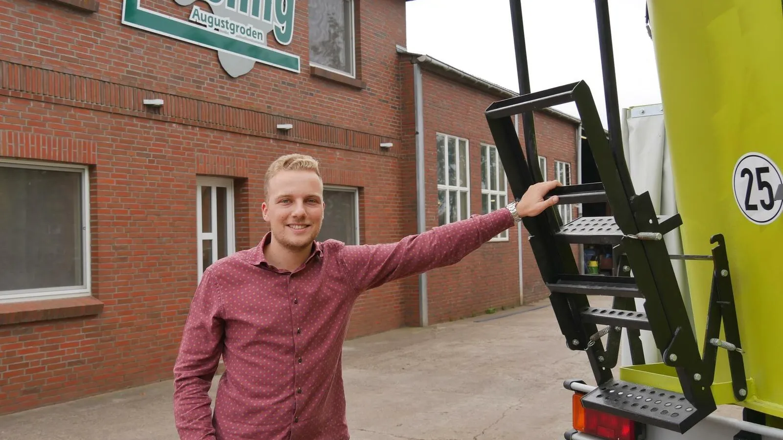 Foto von Mats Ove Müller an einem LKW, er schaut in die Kamera während er eine Hand auf der schwarzen Leiter am LKW hat.