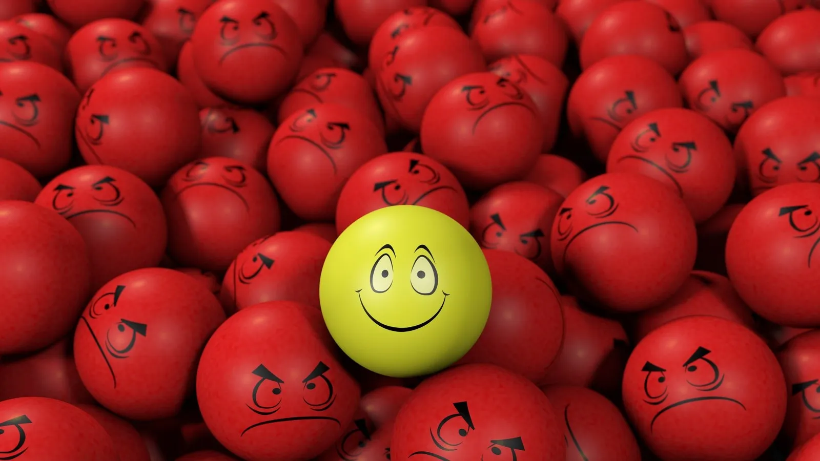 Gelber Ball mit Smiley umringt von verärgerten Gesichtern auf roten Bällen.