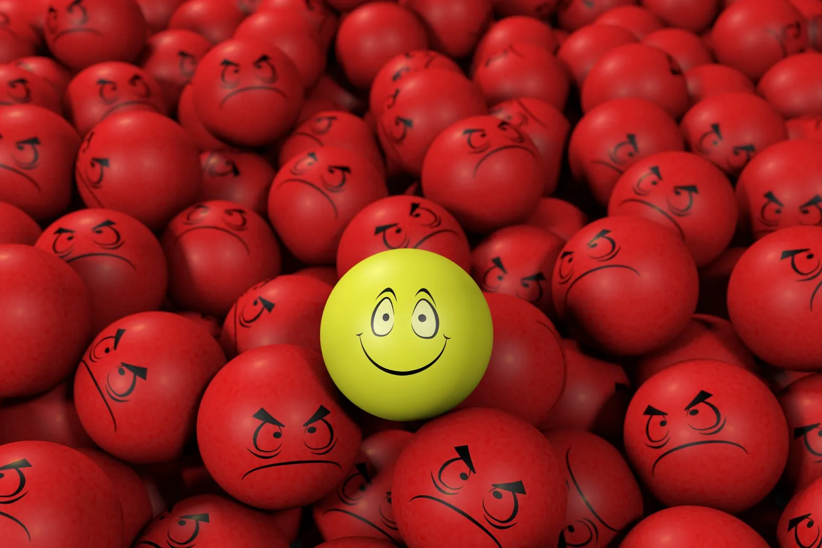 Gelber Ball mit Smiley umringt von verärgerten Gesichtern auf roten Bällen.