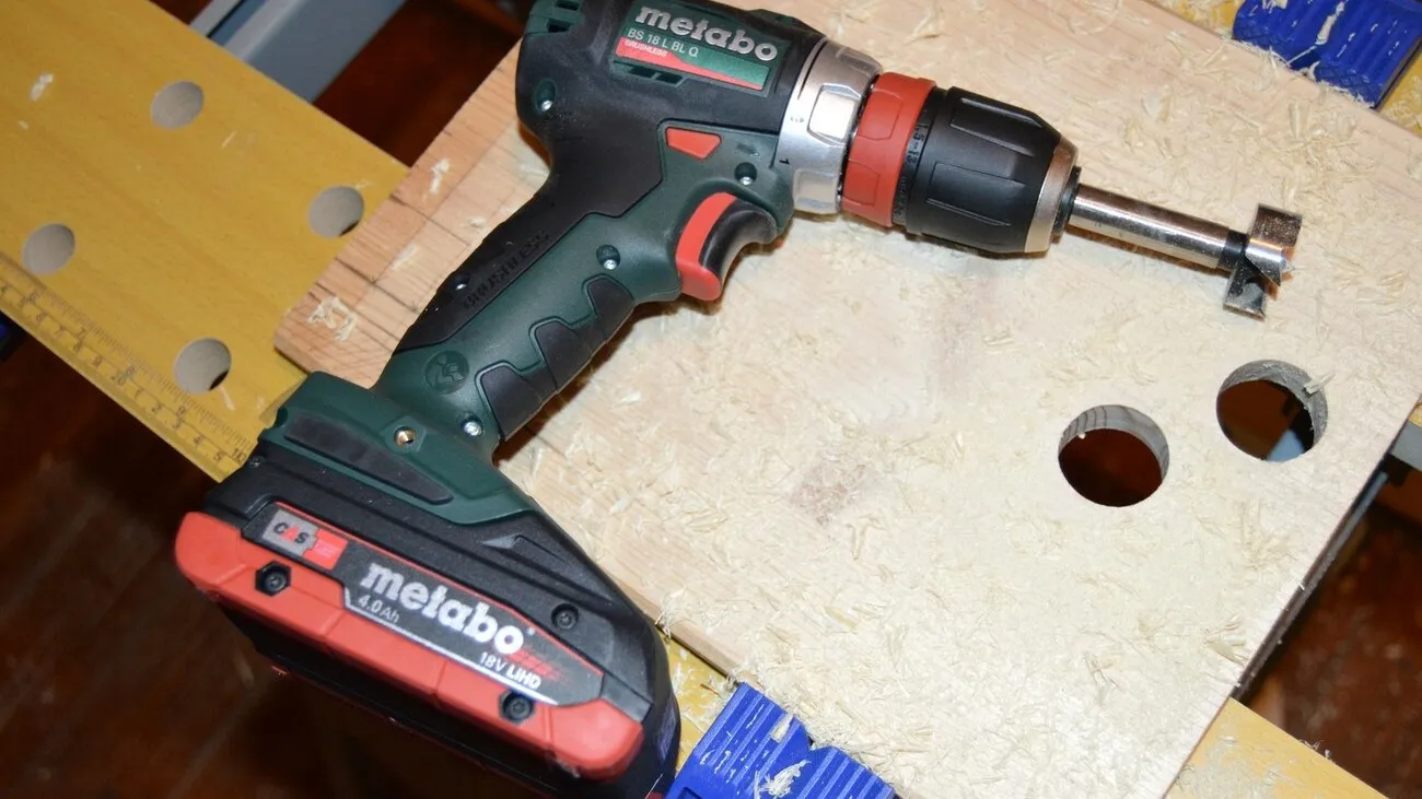 Ein Metabo Akkuschrauber liegt auf einer Werkbank.
