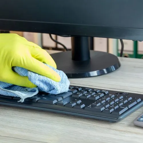 Büroreinigung: Nahaufnahme von der Reinigung eines Büroschreibtisches
