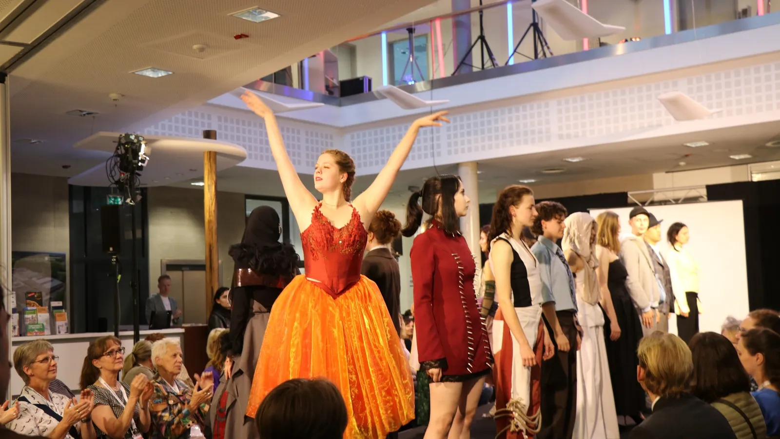 Laufsteg mit Models. Eine von ihnen im Ballettkostüm.