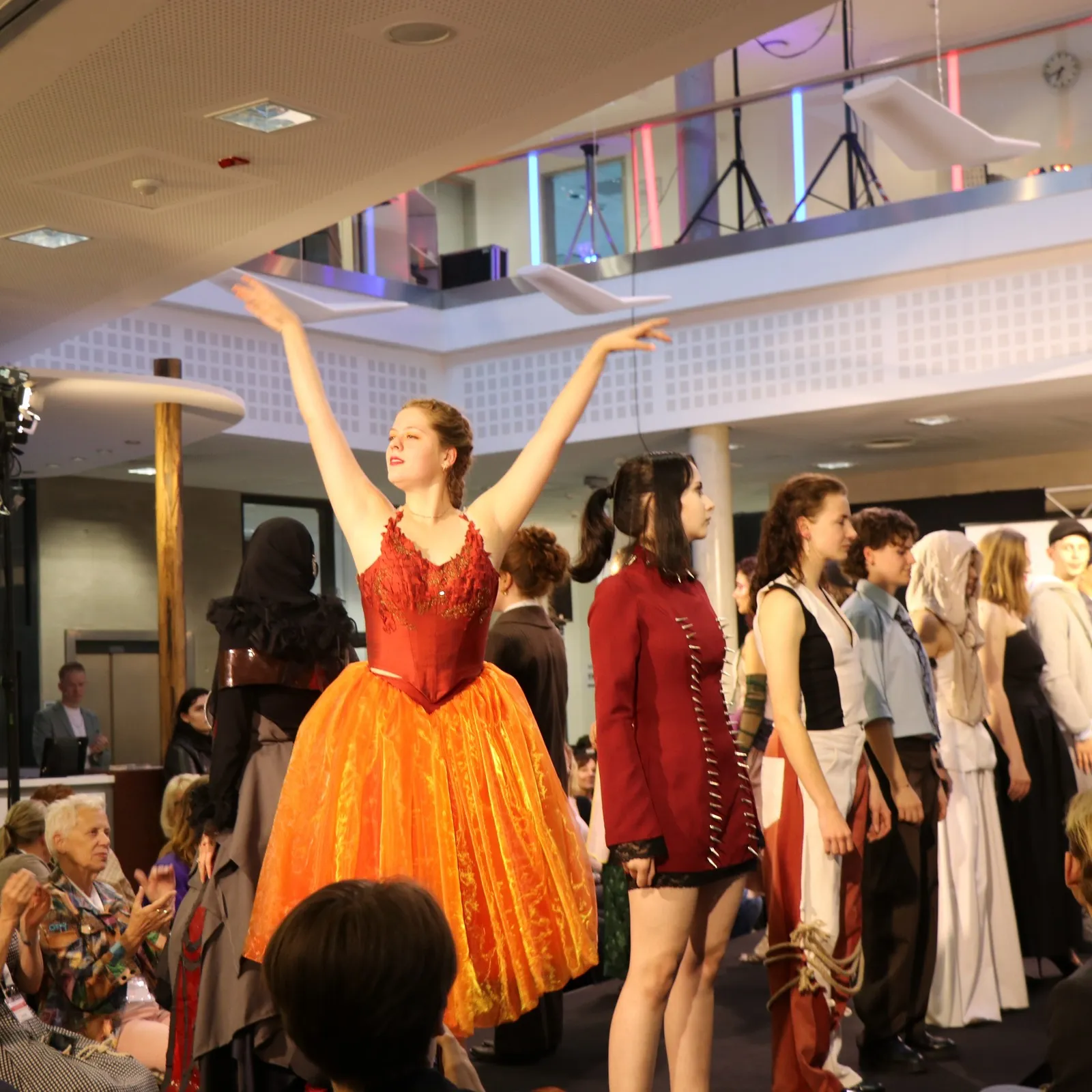Laufsteg mit Models. Eine von ihnen im Ballettkostüm.