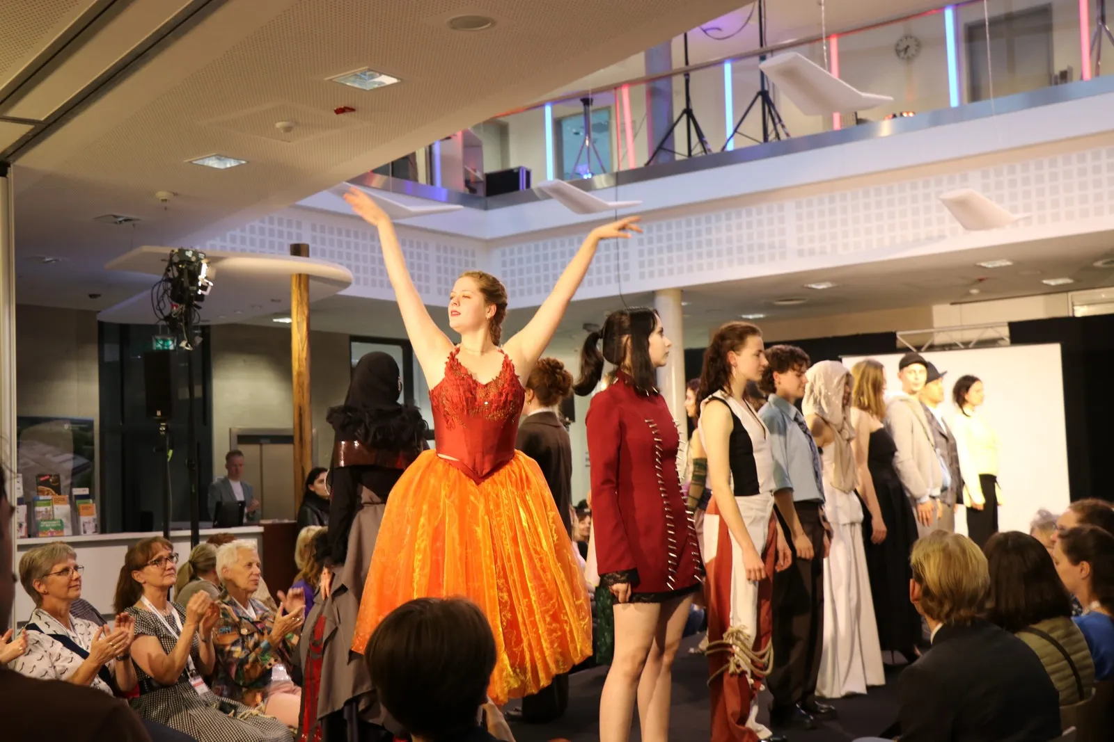 Laufsteg mit Models. Eine von ihnen im Ballettkostüm.