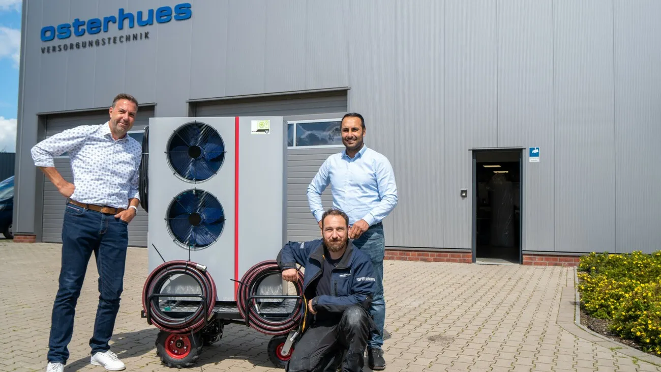 Drei Männer stehen mit der Wärmepumpe draußen für ein Foto: (v.l.r.): Atec-Vertriebsleiter Heiko Bosse, Osterhues-Anlagenmechaniker und Elektriker Fabian von der Lage sowie Osterhues-Geschäftsführer Ahmet Düman.