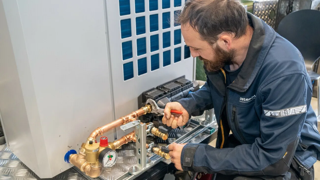 Fabian von der Lage mit letzten Handgriffen an der mobilen Wärmepumpe.
