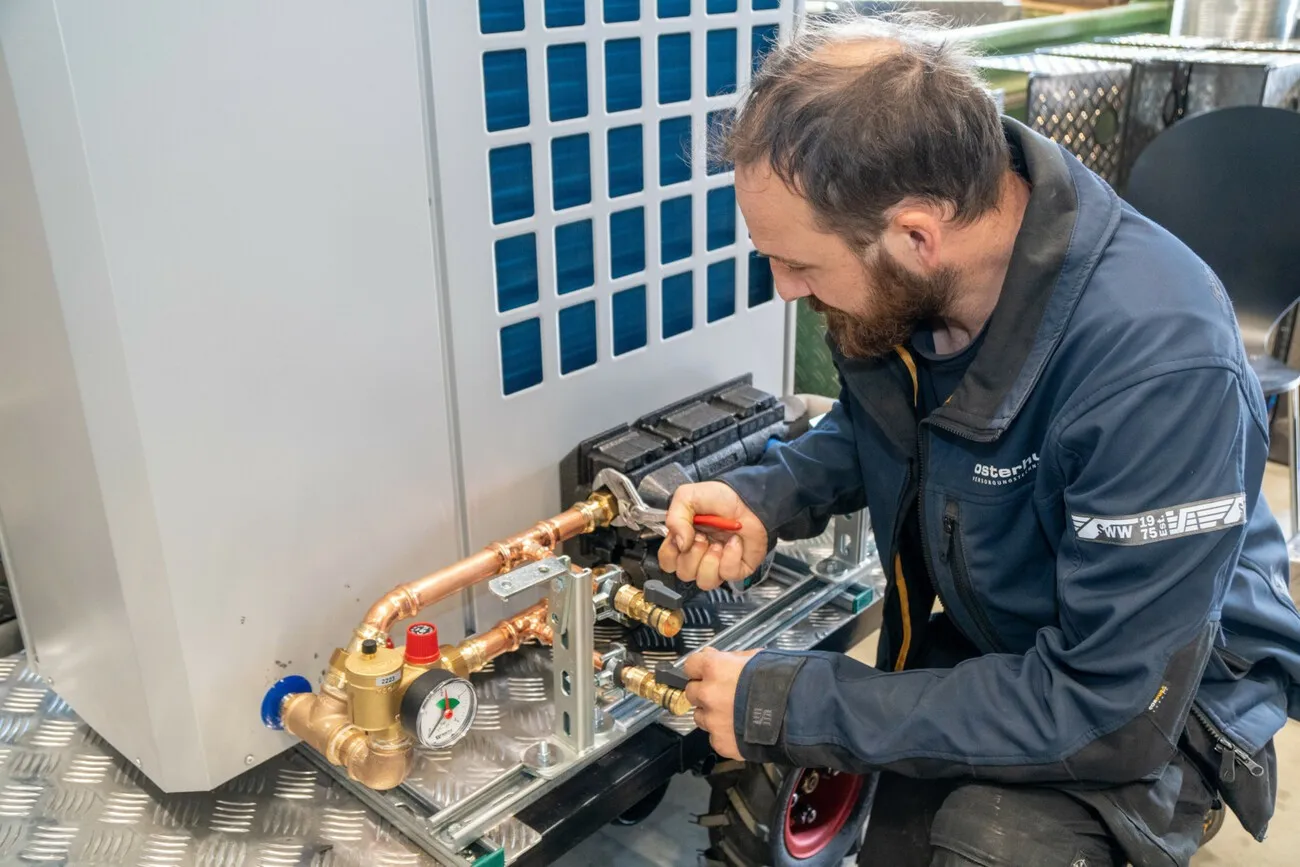 Fabian von der Lage mit letzten Handgriffen an der mobilen Wärmepumpe.