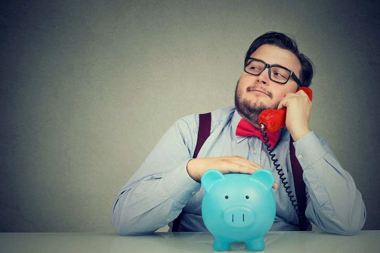 Finanzberater und Banker mit Sparschwein und rotem Telefon