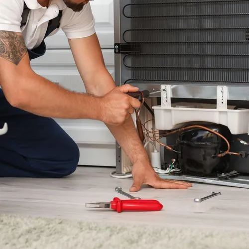 Ein Handwerker repariert einen Kühlschrank.