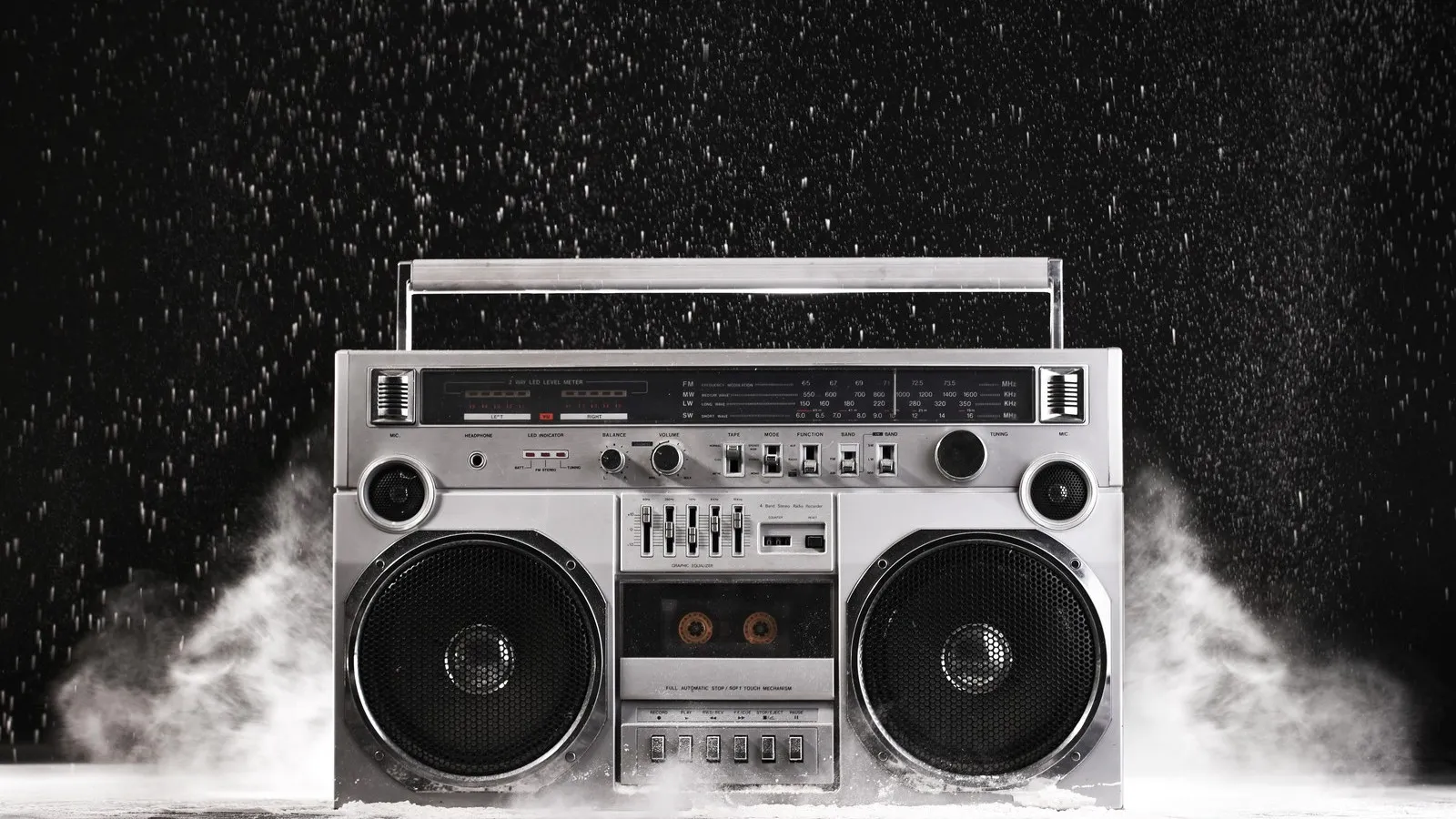 Silbernes Kofferradio im Stil der 1980er-Jahre vor schwarzem Hintergrund.
