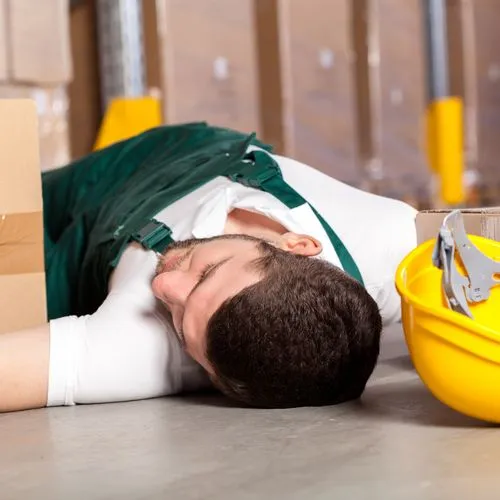 Arbeitsunfall, Mann liegt am Boden mit Helm