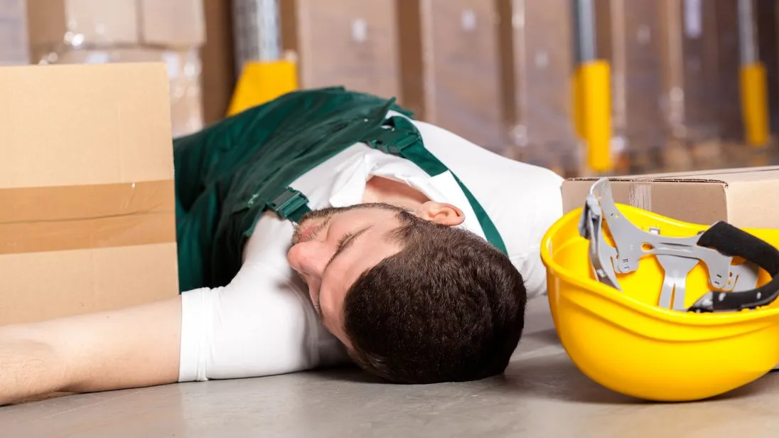Arbeitsunfall, Mann liegt am Boden mit Helm
