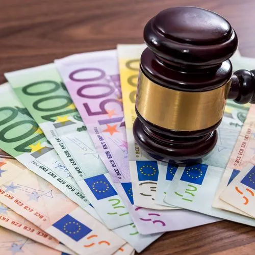 Richterhammer auf Euro-Banknoten. Urteil zu Kostenübernahme.