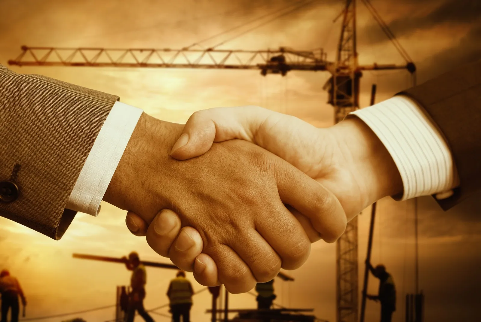 Zwei Männer reichen sich die Hand. Im Hintergrund ist eine Baustelle zu sehen.