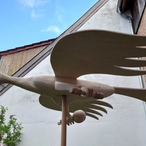 Ein hölzerner Schützenvogel mit Zepter und Reichsapfel auf einer Stange.