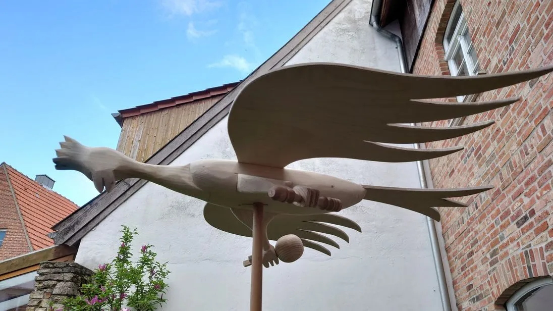 Ein hölzerner Schützenvogel mit Zepter und Reichsapfel auf einer Stange.