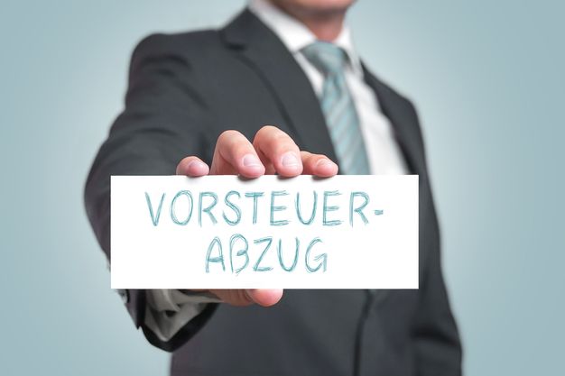 Mann hält ein Schild in die Kamera