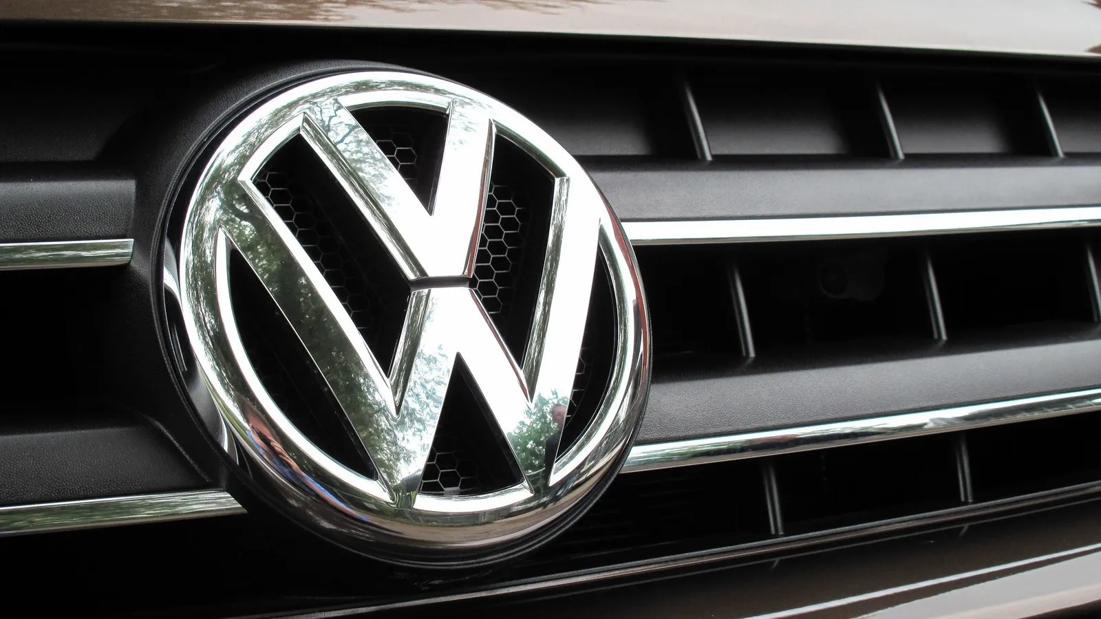 Nahaufnahme des VW Zeichens an einem Fahrzeug.