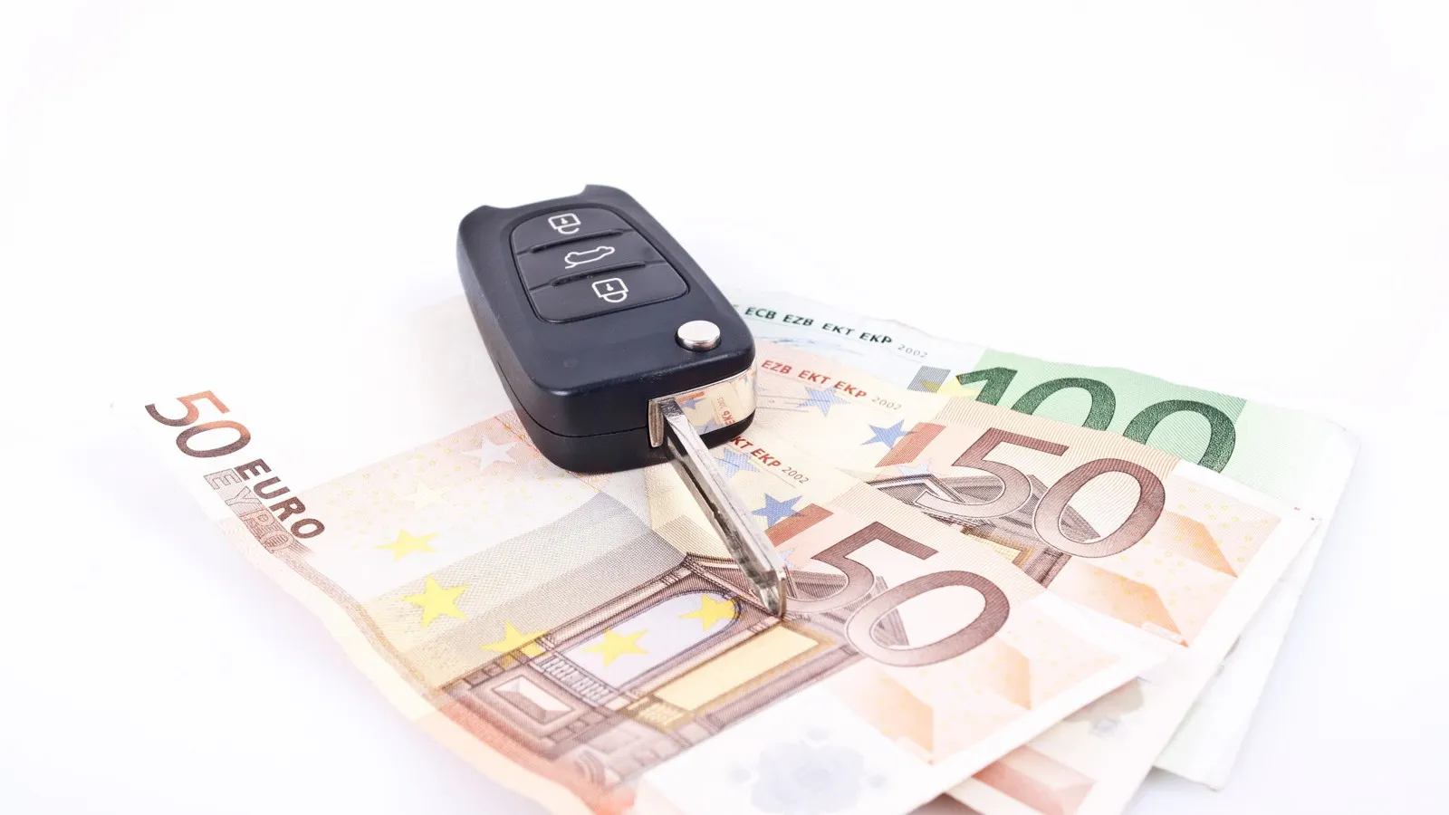 Zwei 50 Euro Scheine und ein 100 Euro Schein liegen halb übereinander, darauf befindet sich ein geöffneter Autoschlüssel.