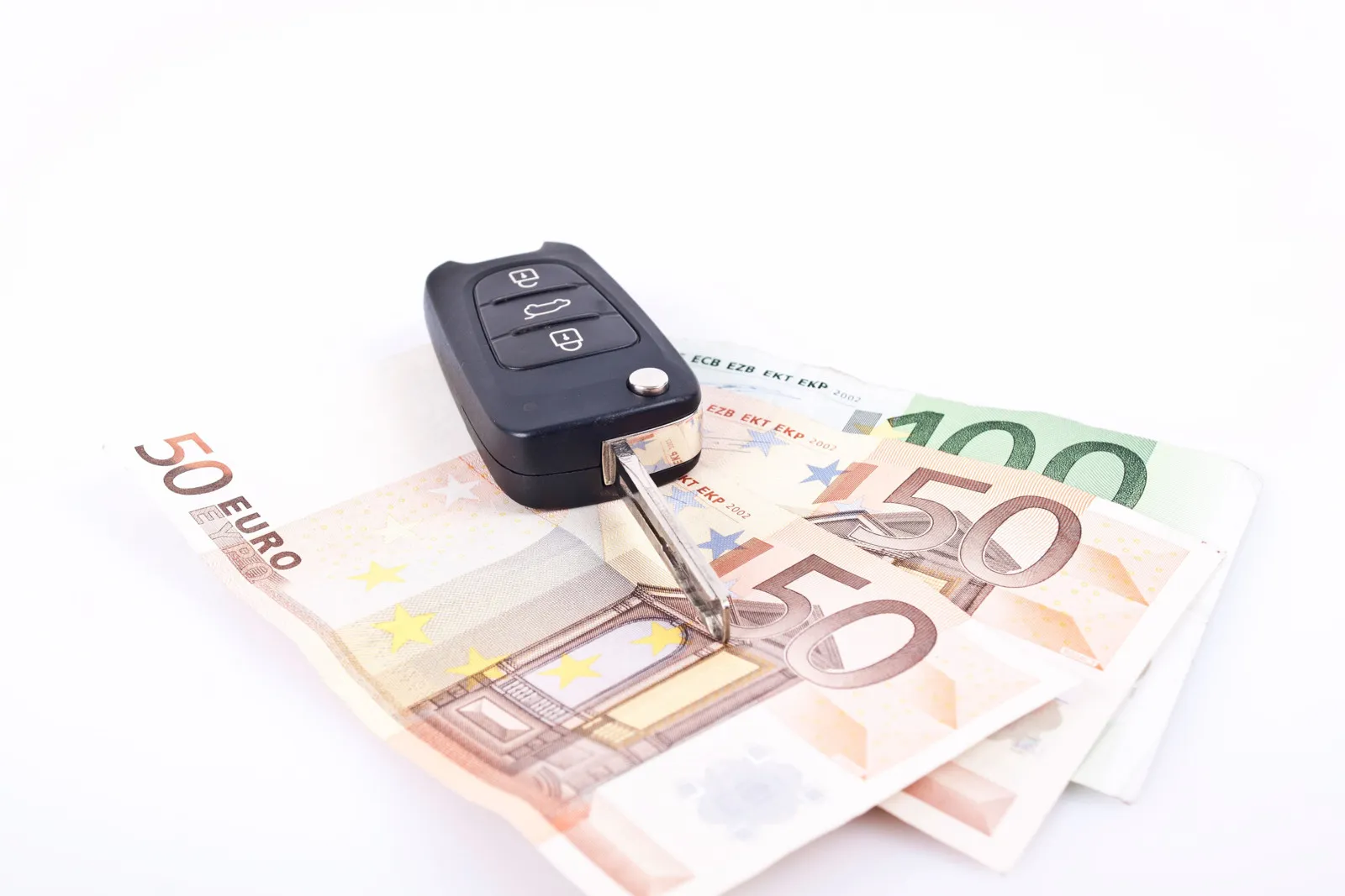 Zwei 50 Euro Scheine und ein 100 Euro Schein liegen halb übereinander, darauf befindet sich ein geöffneter Autoschlüssel.