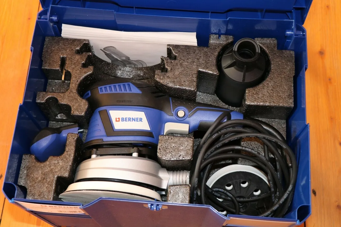 Der blaue Exzenterschleifer Bros-125/150 AVE von Berner in einem Koffer mit Zubehör.