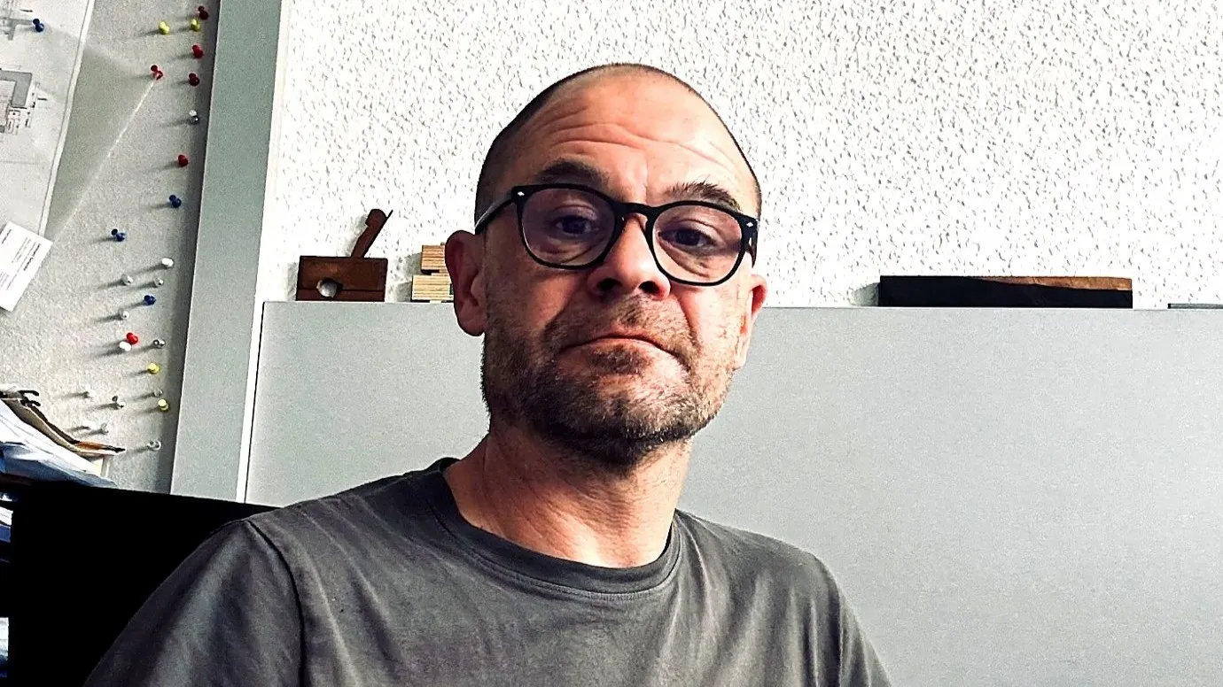 Wolfgang Böhm vor einer weißen Wand.