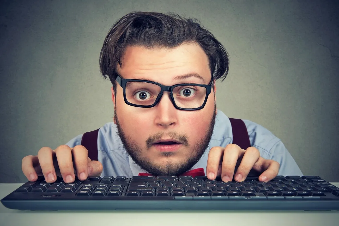Surprised business man typing on key board looking amazed
